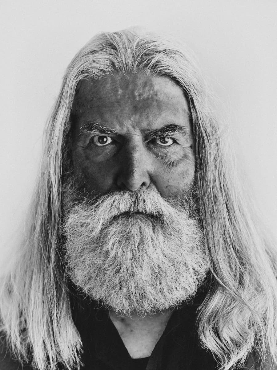 Portrait of a person with long hair and a beard. From Amsterdam Portraits by Bastiaan Woudt.