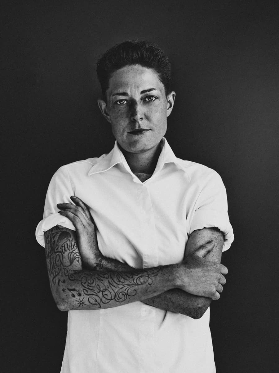 Portrait with crossed arms and a white shirt. From Amsterdam Portraits by Bastiaan Woudt.