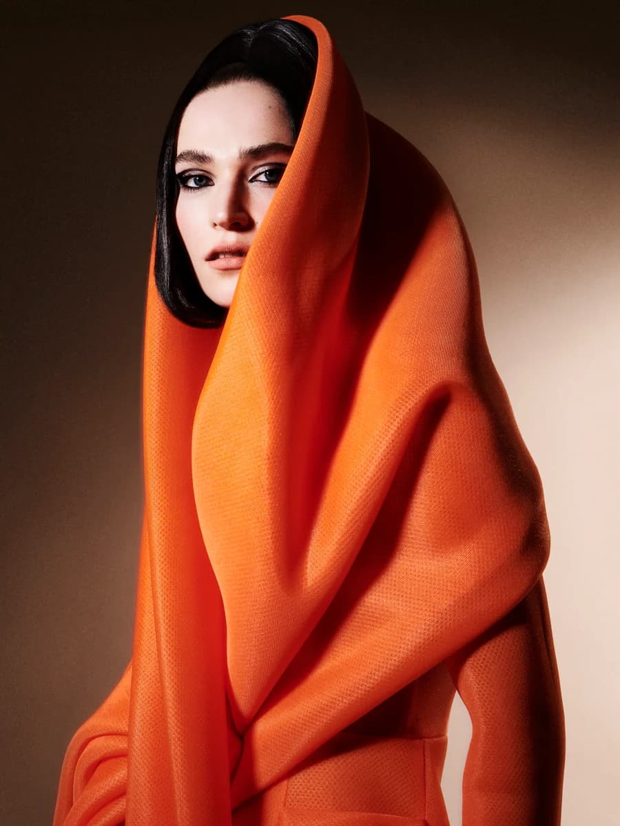 Portrait framed by an orange garment. From Reveal by Tim Verhallen.
