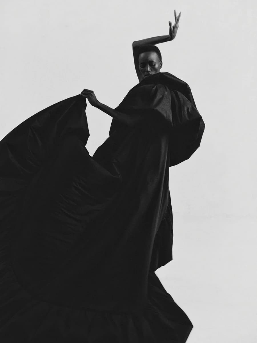 Figure lifting a flowing dark garment. From Rhythm by Bastiaan Woudt.